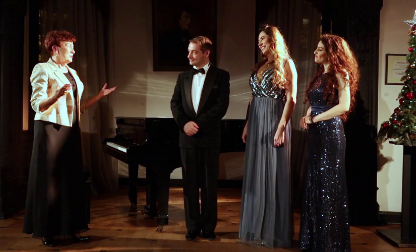 Grazyna Sikorska i troje artystów biorący udział w koncercie stoi na tle fortepianu.