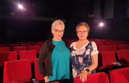Kinga Dębska i prof. Anna Jeremus Lewandowska stoją w Sali Widowiskowej PŁ. Dookoła czerwone fotele w rzędach.