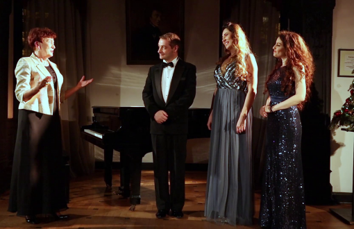 Grazyna Sikorska i troje artystów biorący udział w koncercie stoi na tle fortepianu.