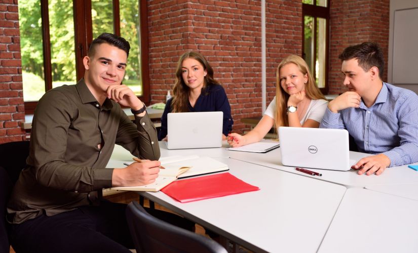 Zdjęcie poglądowe: czwórka studentów siedzą przy stole