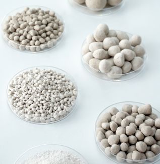 Overview photo: White stones of various sizes in transparent bowls - white background.