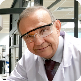 Zdjęcie portretowe: Prof. Andrzej Górak w białym fartuchu i okularach ochronnych w laboratorium.