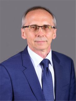 Zdjęcie portretowe: prof. Paweł Strumiłło w niebieskim garniturze i białej koszuli na szarym tle.