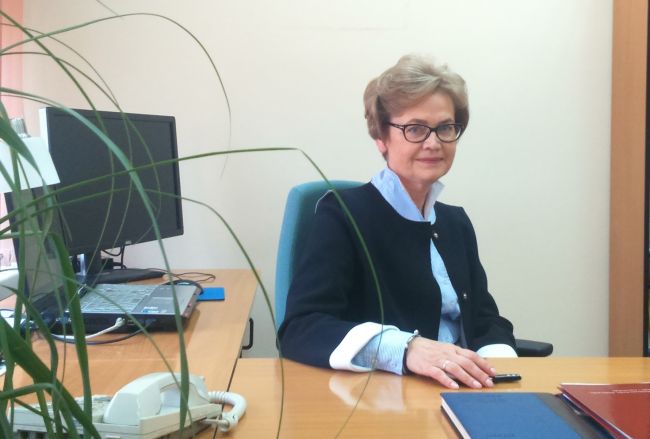 Zdjęcie portretowe: prof. Irena Wasiak siedzi przy biurku