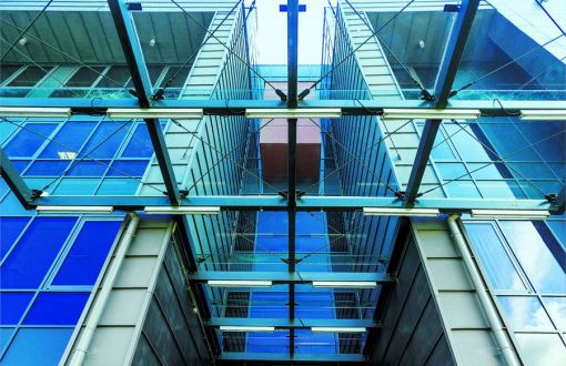 Elementy wejścia do budynku Fabryki Inżynierów PŁ oraz szklanego dachu wielokrotnie się przecinają tworząc artystyczny efekt.