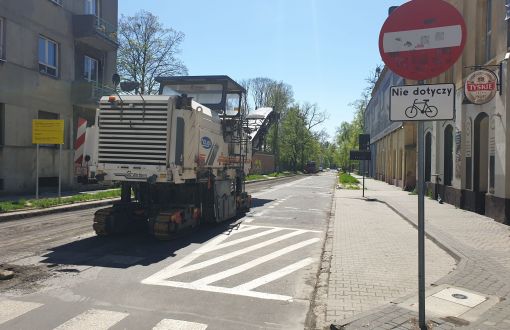 Ul. Stefanowskiego: początek prac nad woonerferm. Zaniedbana ulica i maszyna do ściągania asfaltu.