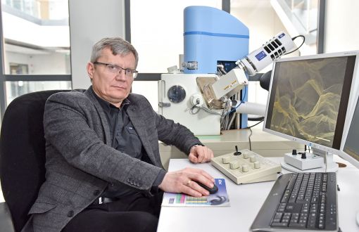 prof. Konrad Dybowski z Wydziału Mechanicznego PŁ siedzi przy stanowisku laboratoryjnym.